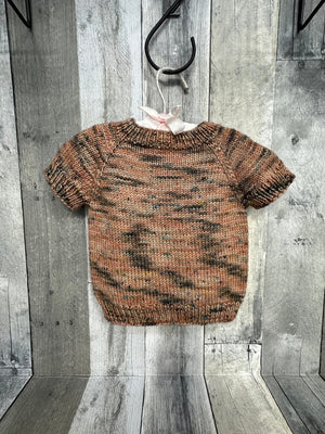 handknig baby pullover sweater hanging from hanger