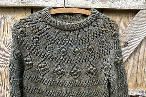 closeup image of the lace and textured yoke of pullover handknit sweater