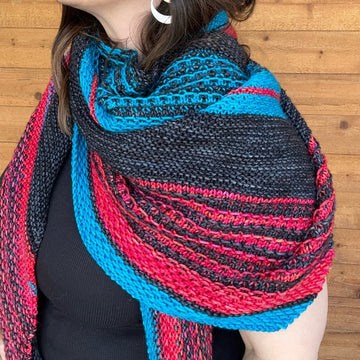 closeup image of striped and textured handknit shawl modeled by a woman
