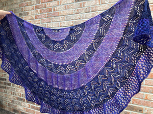 purple lace shawl displayed against a brick wall