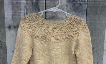 closeup image of the texture of a pullover handknit baby sweater
