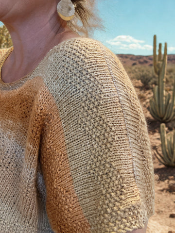 closeup image of a textured stitch pattern on  a handknit top