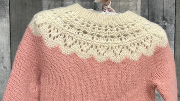 closeup image of the fabric of a 2-color lace yoke pullover handknit baby sweater