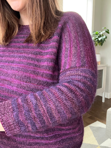 closeup image of the stripe and texture of a handknit pullover sweater
