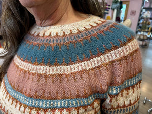 closeup image of the colorwork motif fabric of a handknit pullover sweater