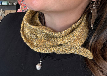 closeup image of a handknit scarflette modeled by a woman