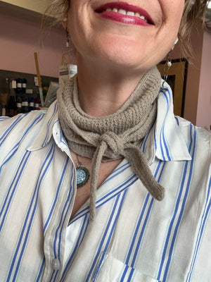 closeup image of a handknit scarflette modeled by a woman