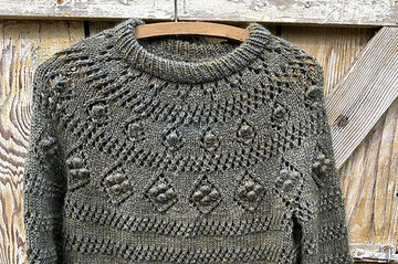 closeup image of the lace and textured yoke of pullover handknit sweater 