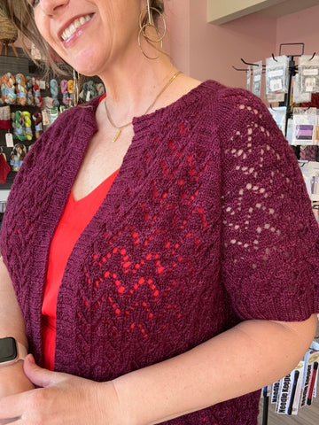 closeup image of the fabric of a lacy short sleeved handknit cardigan
