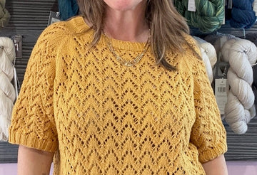 closeup image of the fabric of a lacy short sleeved handknit top