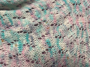 closeup image of a lacework fabric of a handknit shawl