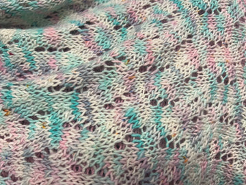closeup image of a lacework fabric of a handknit shawl