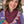 Woman wearing a purple scarf with a colorful patterned shirt in an indoor setting